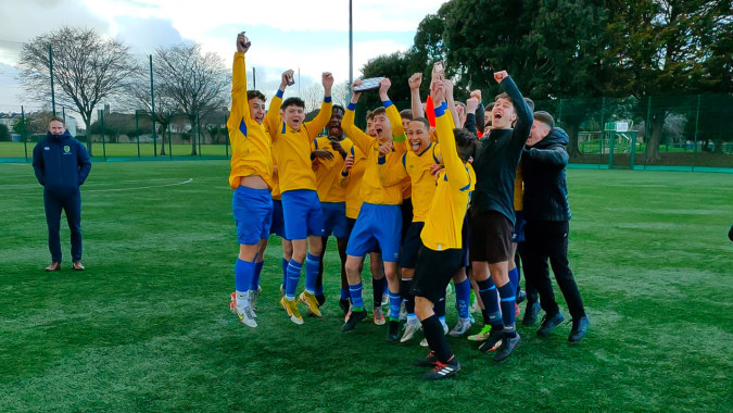 Schüler des Marian College feiern gemeinsam auf dem Fußballfeld vor Bäumen und Gebäuden.