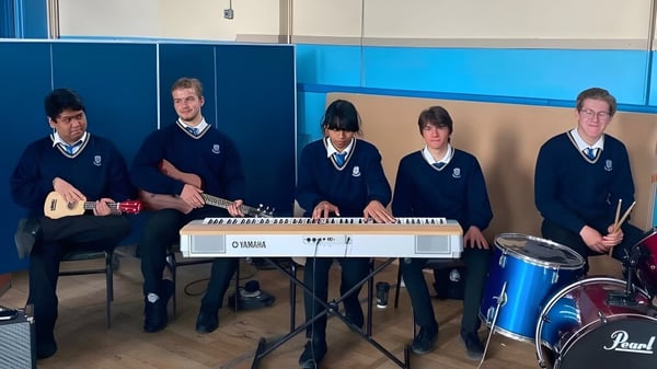 Schüler des Marian College spielen verschiedene Musikinstrumente wie Keyboard und Schlagzeug im Schulgebäude.