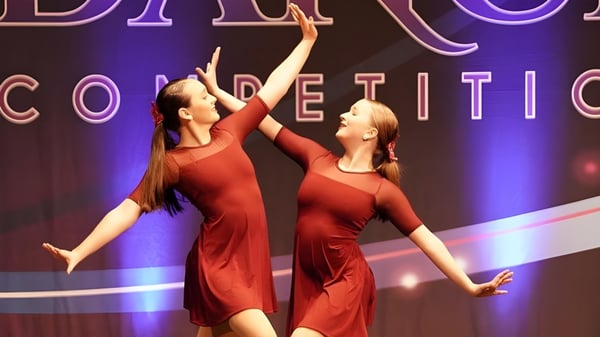 Zwei Tänzerinnen in roten Kleidern treten bei einem Tanzwettbewerb auf der Bühne der Marianapolis Preparatory School auf.