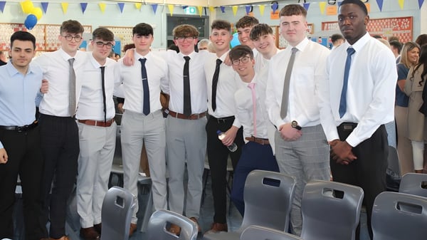 Eine Gruppe Schüler im formellen Outfit steht gemeinsam in einem Klassenraum auf dem Campus des Marist College.