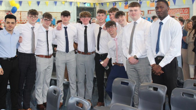 Eine Gruppe männlicher Schüler in formeller Kleidung steht im Klassenraum des Marist College zusammen.