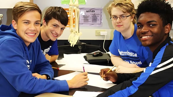 Vier Schüler des Marist College sitzen an einem Tisch und arbeiten gemeinsam in einem Klassenraum.