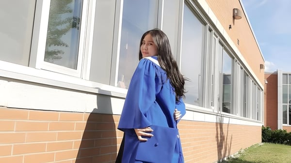 Eine Schülerin steht vor einem Backsteingebäude auf dem Gelände der Markham District High School.