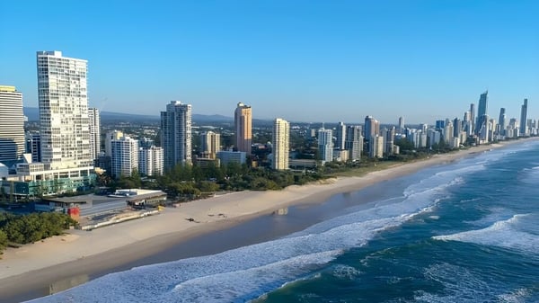 Luftaufnahme einer lebhaften Küstenstadt mit Hochhäusern und Strand, in der Nähe der Maroochydore State High School.
