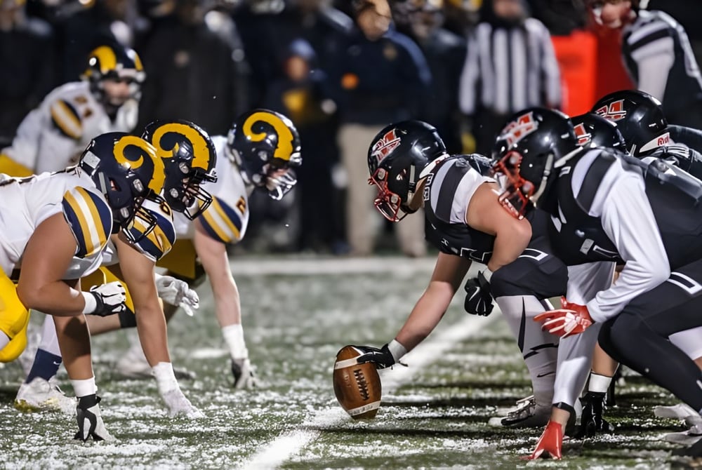 Schüler der Marquette High School stehen in Teamuniform bereit für den nächsten Spielzug im Footballspiel.