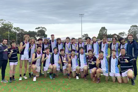 Eine Gruppe von Schülern der Marryatville High School steht auf einem Sportfeld mit Medaillen in der Hand vor einem Stadion.