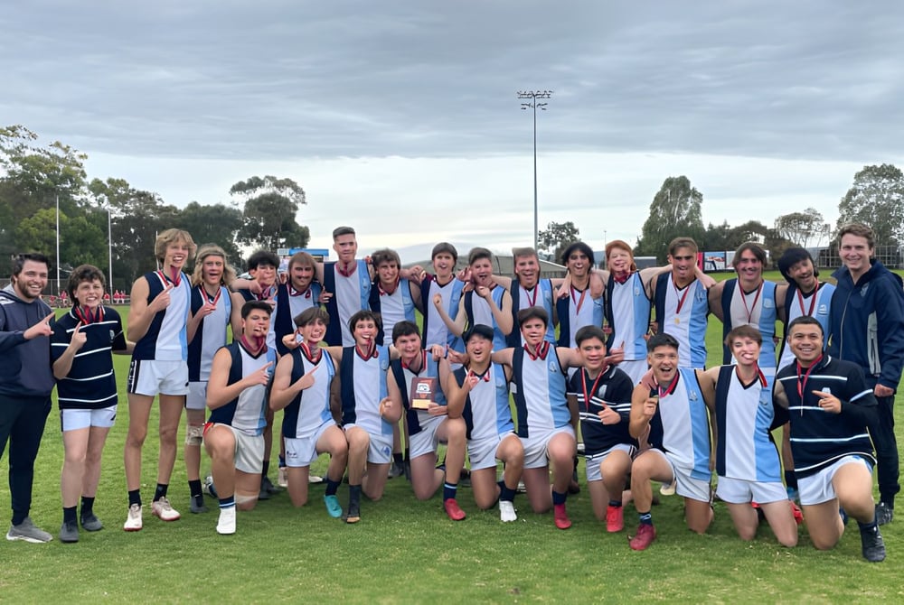 Eine Gruppe von Schülern der Marryatville High School steht auf einem Sportfeld mit Medaillen in der Hand vor einem Stadion.