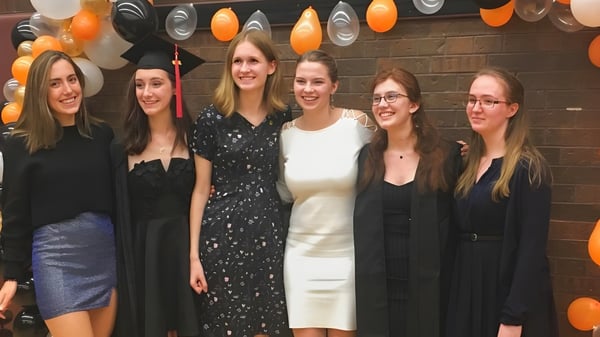 Eine Gruppe Schülerinnen posiert in formeller Kleidung vor einer festlichen Kulisse auf dem Campus der Martingrove Collegiate Institute.