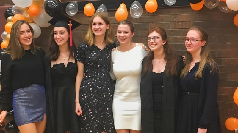 Eine Gruppe Schülerinnen posiert in formeller Kleidung vor einer festlichen Kulisse auf dem Campus der Martingrove Collegiate Institute.