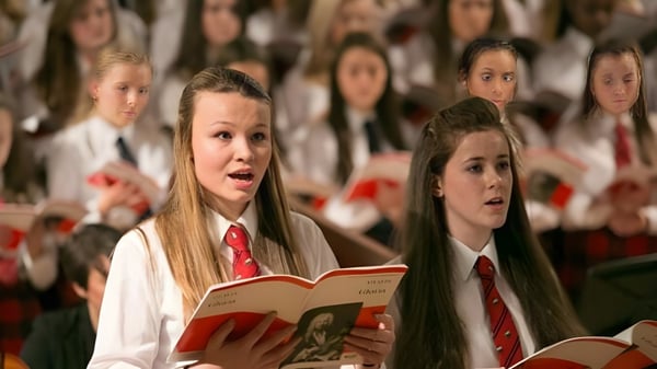 Schülerinnen und Schüler der Mary Erskine School singen gemeinsam im Chor auf einer Bühne.