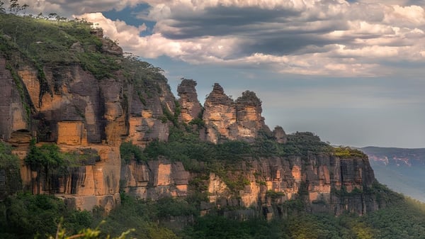 Felsenformationen ragen vor bewölktem Himmel in der natürlichen Umgebung der Maryborough State High School empor.