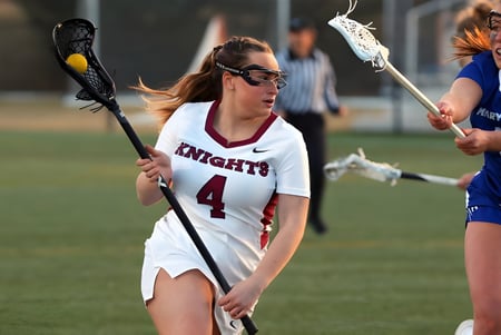 Eine Lacrosse-Spielerin der Marymount Academy International läuft mit dem Schläger auf dem Spielfeld.