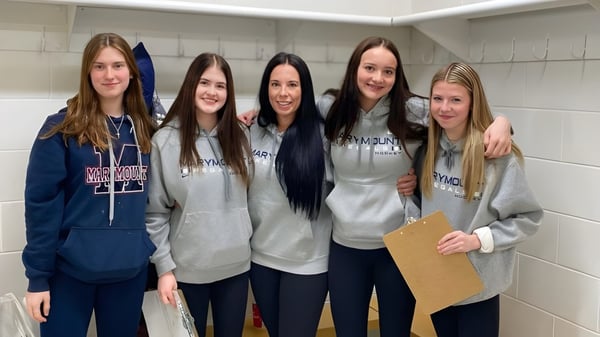 Fünf junge Schülerinnen stehen gemeinsam im Flur der Marymount Academy vor Schließfächern.