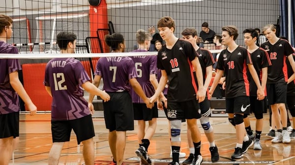 Eine Gruppe junger Volleyballspielerinnen und -spieler auf dem Volleyballfeld der Master's Academy and College versammelt.