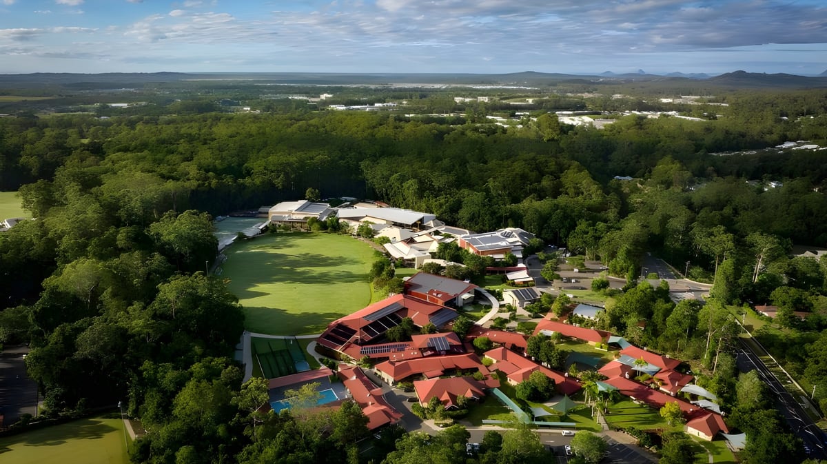 Die grüne Landschaft mit dem Matthew Flinders Anglican College Resort und Blick auf das ländliche Gebiet mit Hügeln im Hintergrund.