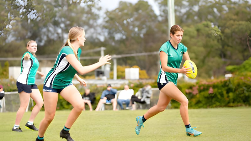 Schüler des Matthew Flinders Anglican College spielen auf dem Sportfeld umgeben von Bäumen und Vegetation.