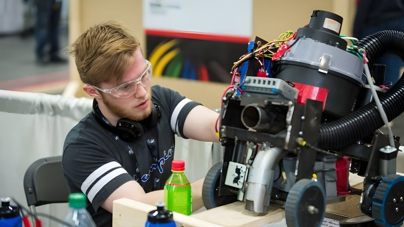 Ein Schüler der Matthew Halton High School arbeitet konzentriert an technischer Ausrüstung in einer Werkstatt.