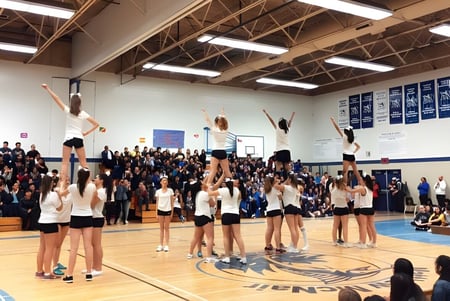 Eine Gruppe junger weiblicher Sportlerinnen führt Gymnastikübungen in der Halle der Matthew McNair Secondary School vor Zuschauern auf.