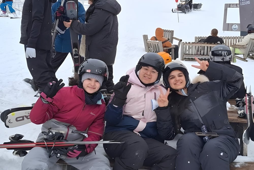 Eine Gruppe Schülerinnen und Schüler der École secondaire publique Maurice Lapointe trägt Winterkleidung bei einem Ausflug im Schnee mit Skiausrüstung.