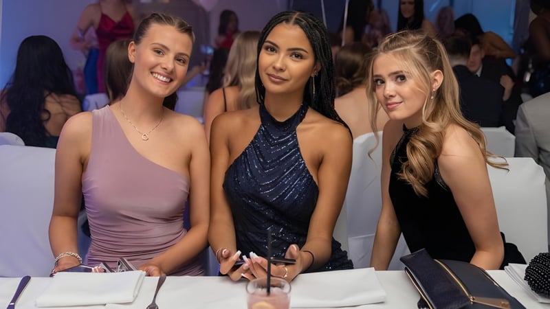 Drei Schülerinnen der Mayfield School posieren gemeinsam bei einem formellen Schulereignis.