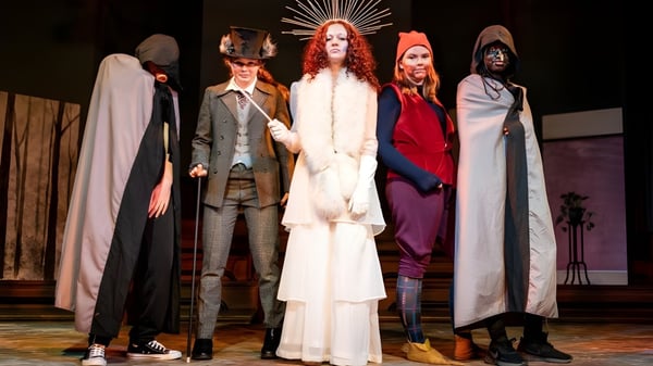 Eine Gruppe von Schülern der Mayfield School steht in aufwändigen Theaterkostümen auf der Bühne vor dunklem Hintergrund.