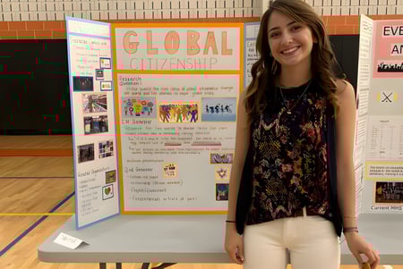 Eine Schülerin steht vor einer Präsentation zum Thema Global Citizenship auf dem Campus der Maynard High School.