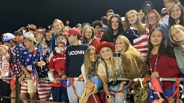 Eine Gruppe von Schülerinnen und Schülern der Maynard High School in patriotischer Kleidung posiert gemeinsam lächelnd für ein Gruppenfoto.