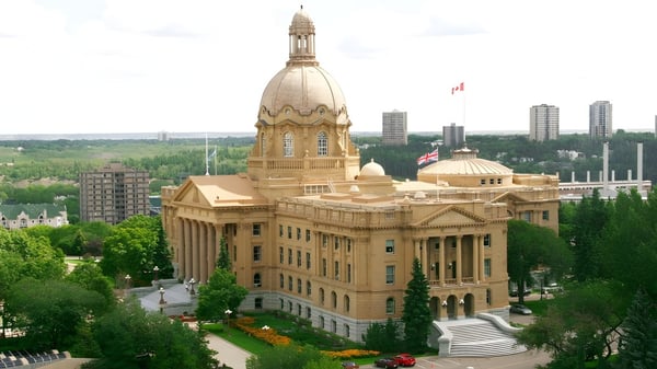 Ein imposantes Regierungsgebäude mit Kuppel und Turm vor moderner Skyline auf dem Gelände der McNally High School.