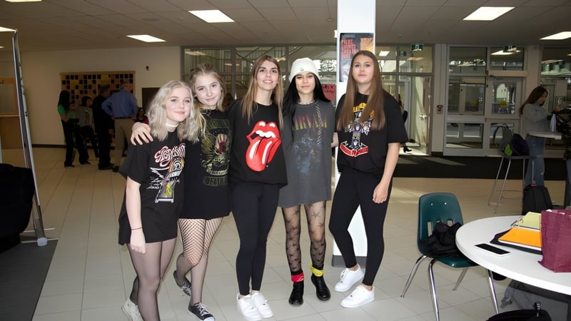 Eine Gruppe Schülerinnen der Medicine Hat High School steht in einem Raum mit Tischen und Stühlen.