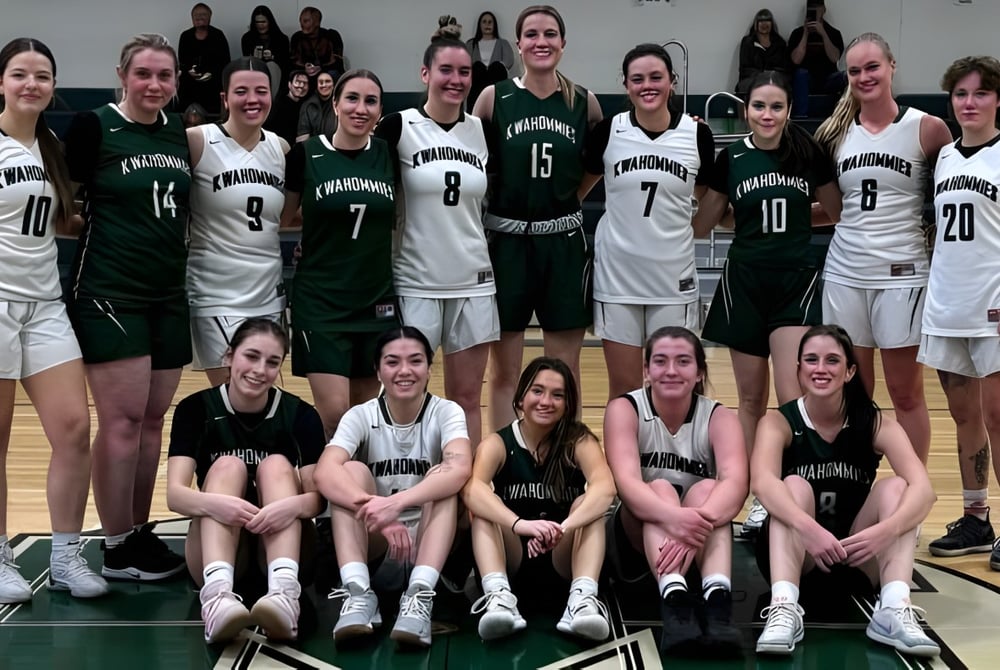 Eine Gruppe Schülerinnen der Medicine Hat High School posiert gemeinsam auf dem Basketballfeld.