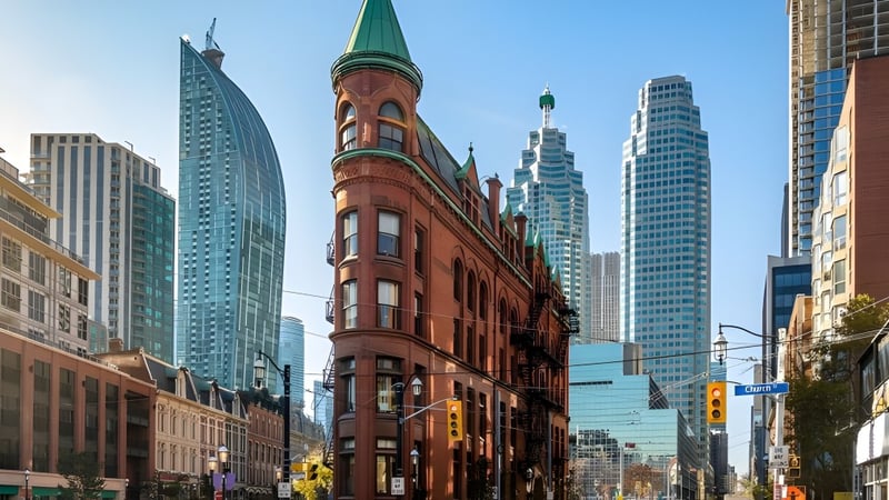 Das historische Backsteingebäude der Medway High School steht vor modernen Wolkenkratzern in der Stadt.