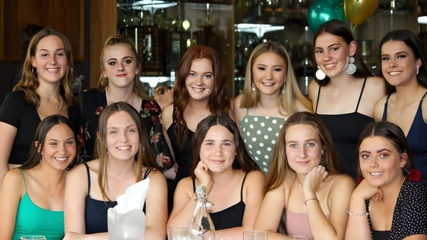 Eine Gruppe Schülerinnen der Melville Senior High School versammelt sich in einem festlich dekorierten Raum.