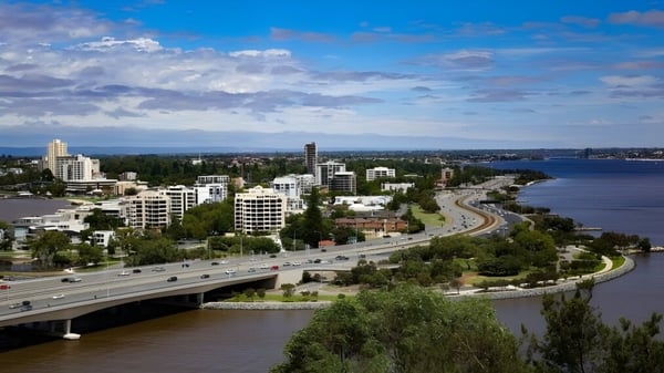 Blick auf eine weitläufige Stadtlandschaft mit Hochhäusern und Wasser im Vordergrund, nahe der Melville Senior High School.