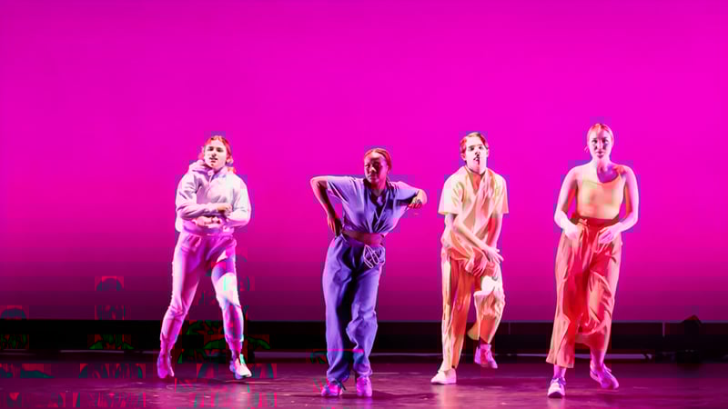 Vier Schüler der Mercersburg Academy stehen in bunten Kostümen vor einem pinken Hintergrund während einer Performance.