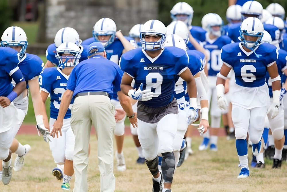 Eine Gruppe von Fußballspielern in Blau-Weiß auf dem Sportfeld der Mercersburg Academy.