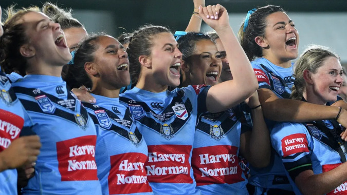 Eine Gruppe weiblicher Athletinnen feiert gemeinsam auf einem Spielfeld am Mercy College.