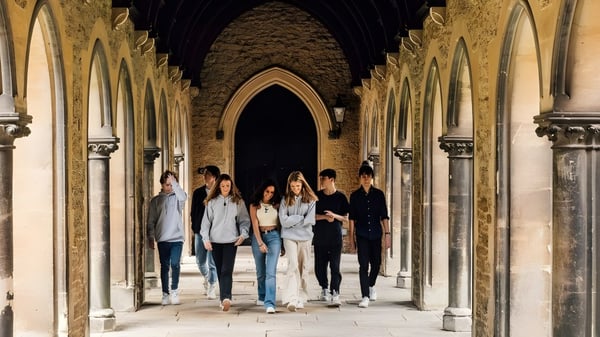 Eine Gruppe Schülerinnen und Schüler geht durch den kunstvoll gestalteten Bogengang der Mercy Secondary School.