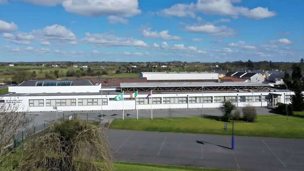 Das weiße Industriegebäude auf dem Gelände der Mercy Secondary School Ballymahon unter einem blauen Himmel mit Wolken.