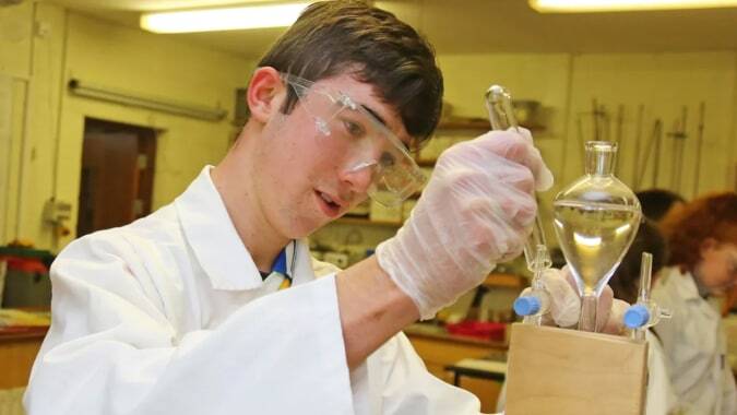 Eine Schülerin oder ein Schüler der Mercy Secondary School arbeitet sorgfältig mit wissenschaftlichem Equipment im Labor.
