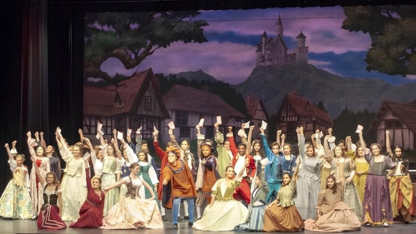 Schüler der Mercy Secondary School Ballymahon stehen vor einer Kulisse mit einem imposanten Schloss und dramatischem Himmel.