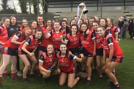 Eine Gruppe junger Sportlerinnen feiert einen Erfolg auf dem Sportplatz der Mercy Secondary School Ballymahon.