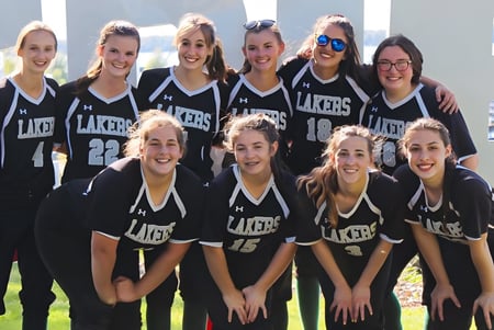 Eine Gruppe von Schülerinnen der Mercyhurst Prep School posiert im Freien in Lakers-Sporttrikots.