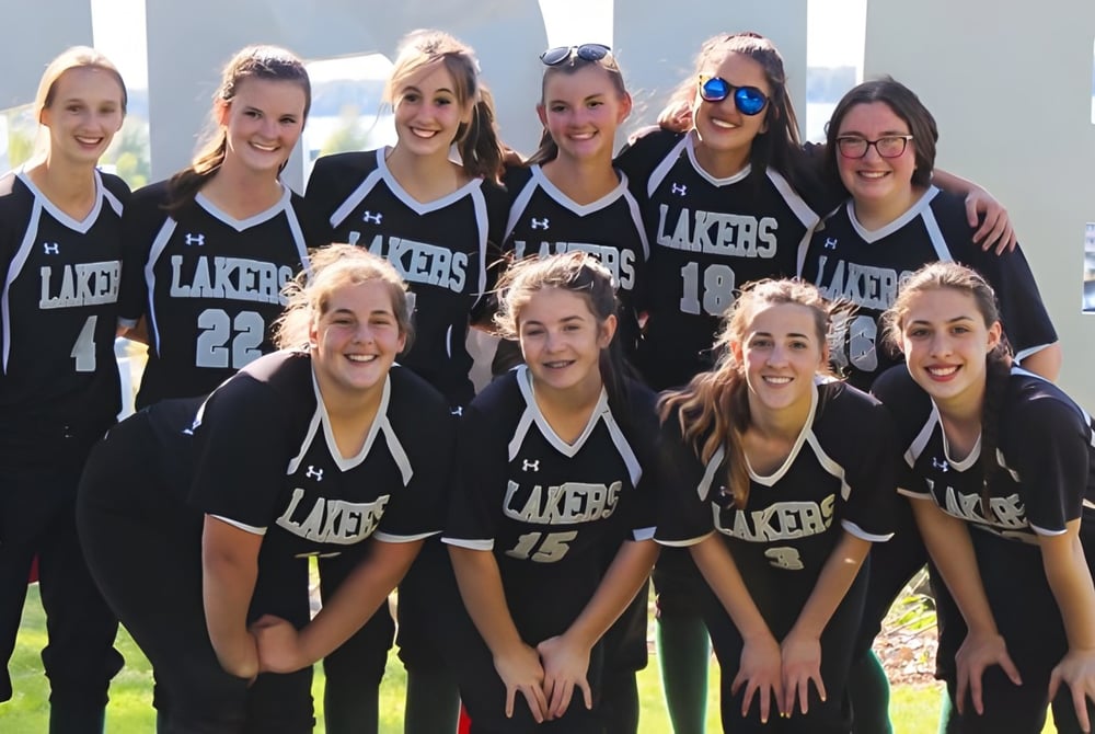 Eine Gruppe von Schülerinnen der Mercyhurst Prep School posiert im Freien in Lakers-Sporttrikots.