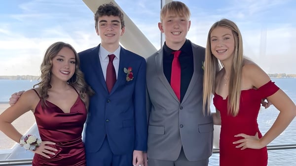 Vier Schüler der Mercyhurst Prep School posieren gemeinsam auf einem Boot mit Wasser und Himmel im Hintergrund.