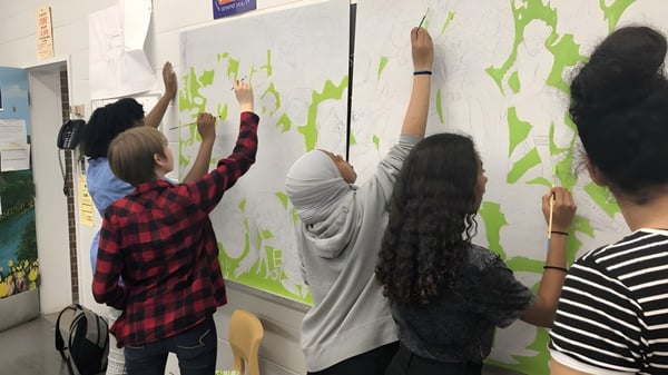 Schüler der Merivale High School arbeiten gemeinsam an einem bunten Wandbild mit künstlerischen Elementen.