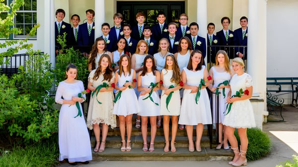 Eine Gruppe von Schülerinnen der Merrick Preparatory School steht gemeinsam auf den Stufen eines repräsentativen Gebäudes umgeben von grüner Bepflanzung.