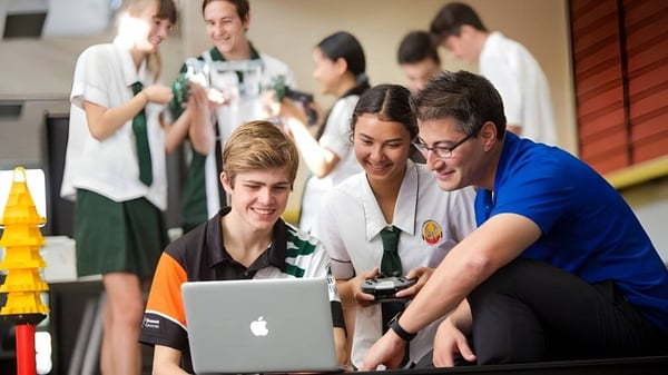 Eine Gruppe Schülerinnen und Schüler der Merrimac State High School arbeitet gemeinsam an einem Laptop.