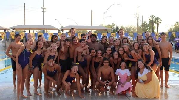 Eine Gruppe von Schülern der Mesa High School versammelt sich im Schwimmbeckenbereich für ein Gruppenfoto.
