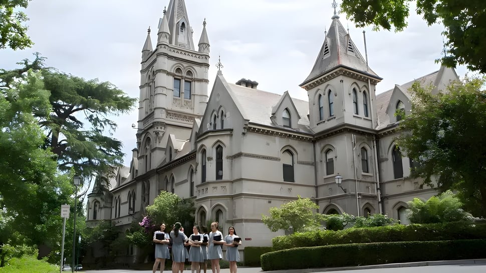 Vor der prächtigen Kathedrale sitzen eine Gruppe Menschen auf einer Wiese auf dem Gelände des Methodist Ladies' College.