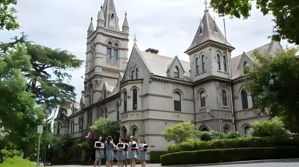 Vor der prächtigen Kathedrale sitzen eine Gruppe Menschen auf einer Wiese auf dem Gelände des Methodist Ladies' College.